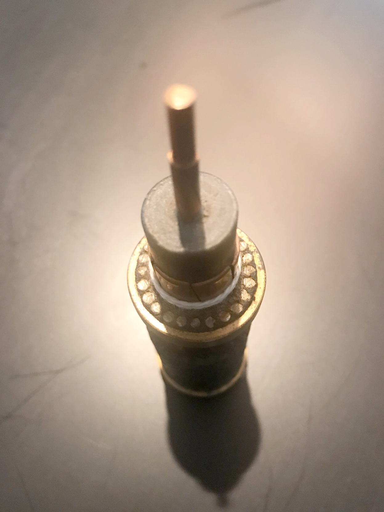 close-up of a cut-away section of a cable, with a center copper wire sticking out of the black polyethlene insulating layer, and a group of steel wires surrounding it