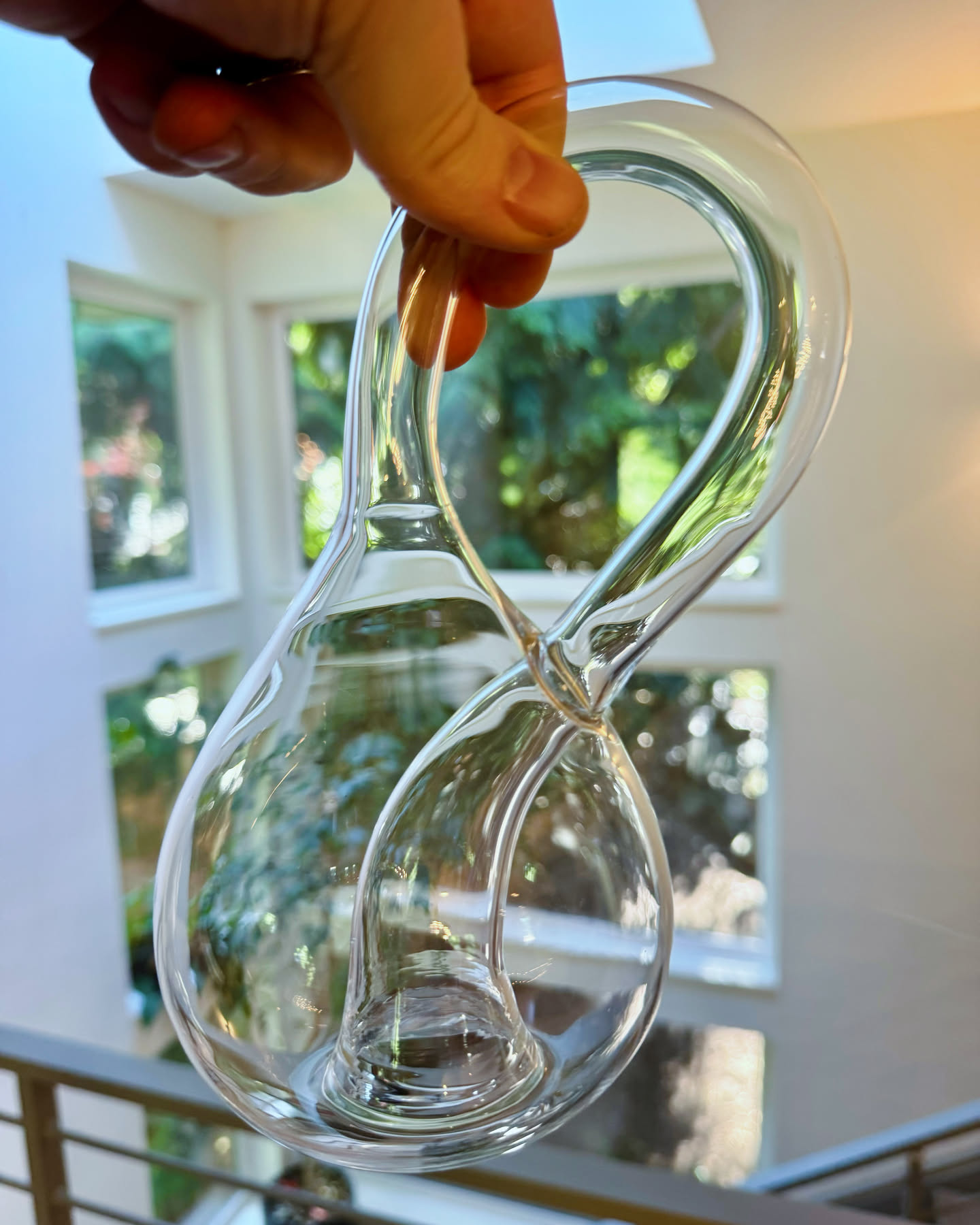 me holding a small glass klein bottle in front of our atrium