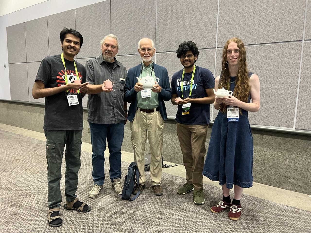 Photo of Kai Deshpande, Erik Brunvand, Martin Newell, Rushikesh Vidye, and Thalia Archibald holding various teapots.